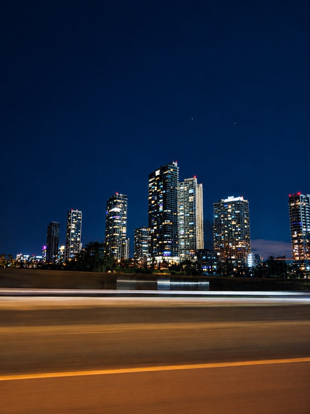 City skyline at night with long-exposure light trails